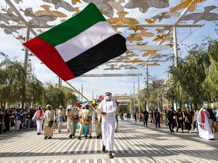 citizen of UAE waving a big flag on the UAE national day